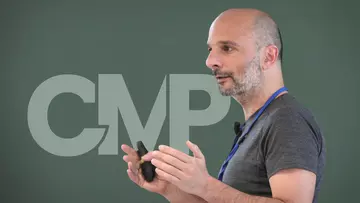 Massimiliano Gubinelli hält einen Colloqium-Vortrag mit dem CMP-Logo im Hintergrund